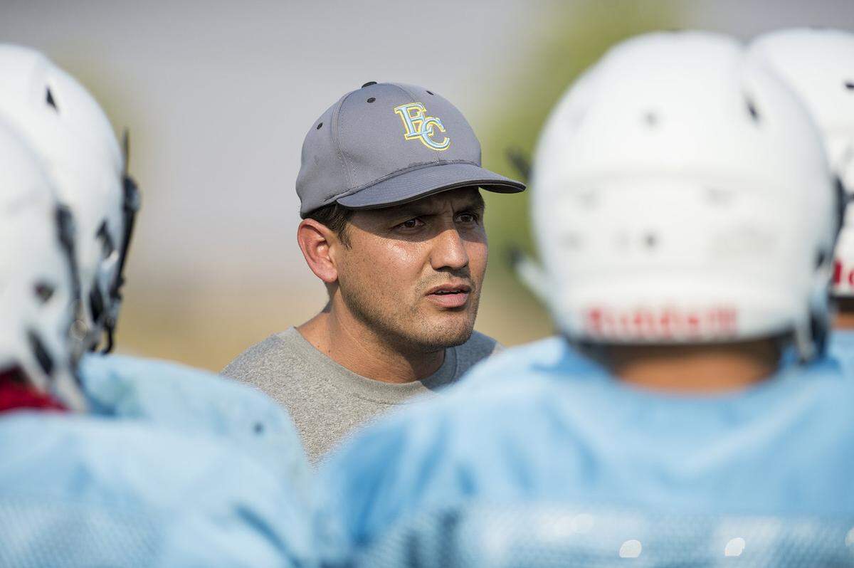 Head coach Frank Solis speaks to players during football practice at El Capitan High School in Merced, Calif., on Wednesday, Aug. 8, 2018.