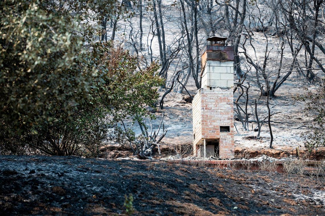 A chimney remains standing on a property damaged by fire along Triangle Road in Mariposa County, Calif., as firefighters continue to battle the Oak Fire on Tuesday, July 26, 2022.