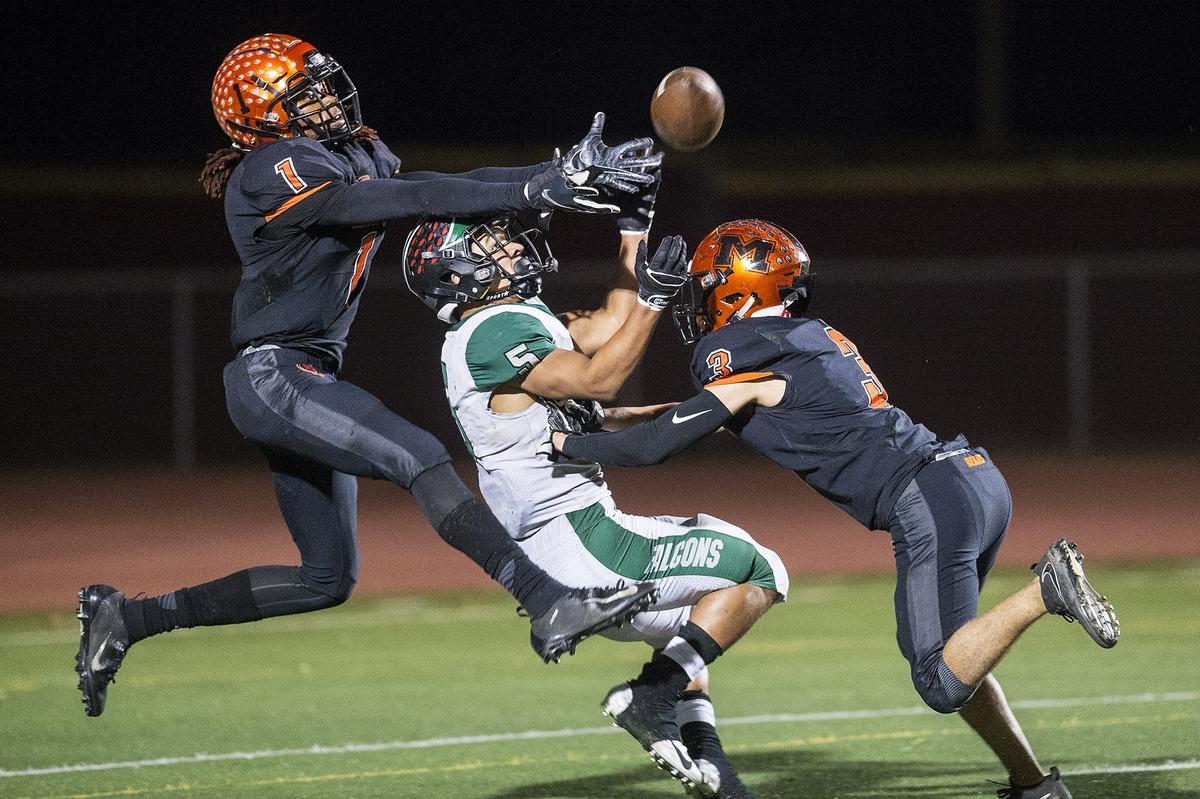 Merced seniors Dhameer Warren (1) and Ronnie Miranda III (3) break up a pass intended for River Valley senior Evan Strickland (5) during a CIF Sac-Joaquin Section Division III playoff game at Veterans Stadium in Merced, Calif., on Friday, Nov. 9, 2018. The Falcons beat the Bears 45-40.