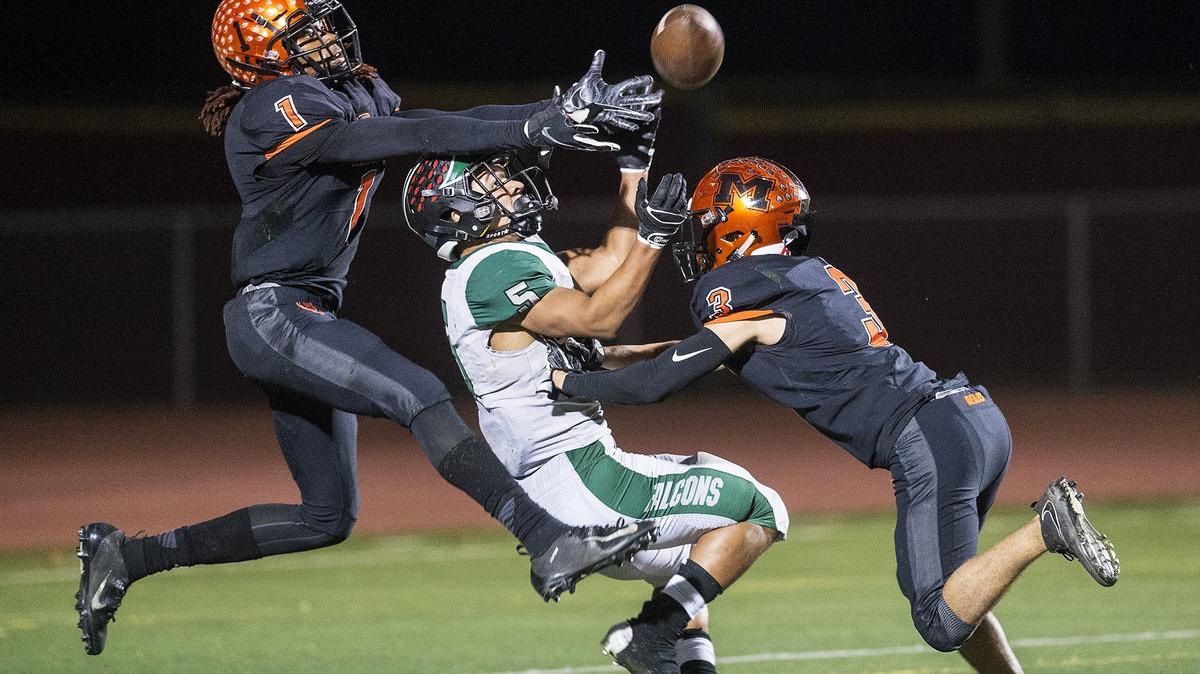 Merced seniors Dhameer Warren (1) and Ronnie Miranda III (3) break up a pass intended for River Valley senior Evan Strickland (5) during a CIF Sac-Joaquin Section Division III playoff game at Veterans Stadium in Merced, Calif., on Friday, Nov. 9, 2018. The Falcons beat the Bears 45-40.
