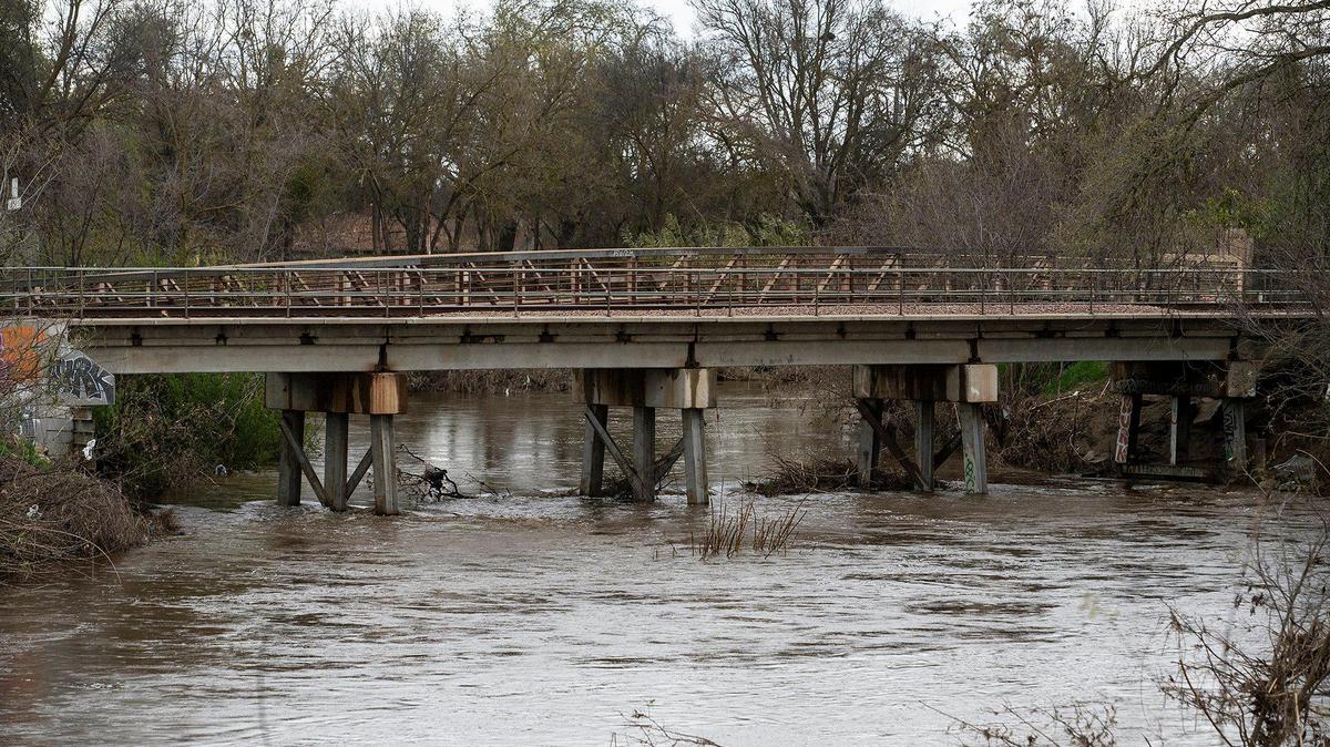 Bear Creek flows past a railroad bridge near West 25th Street in Merced, Calif., on Tuesday, March 14, 2023.