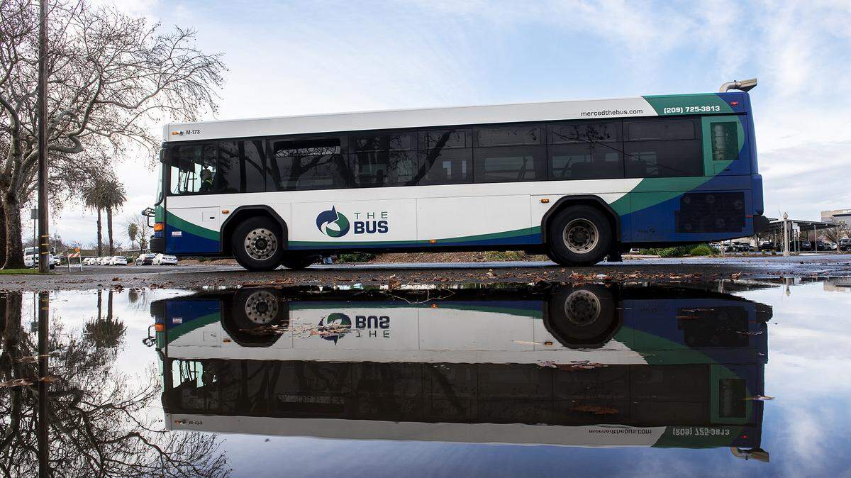 A bus drives past a flooded section of roadway at the intersection of West 23rd and Canal streets in Merced, Calif., on Wednesday, Jan. 4, 2023.