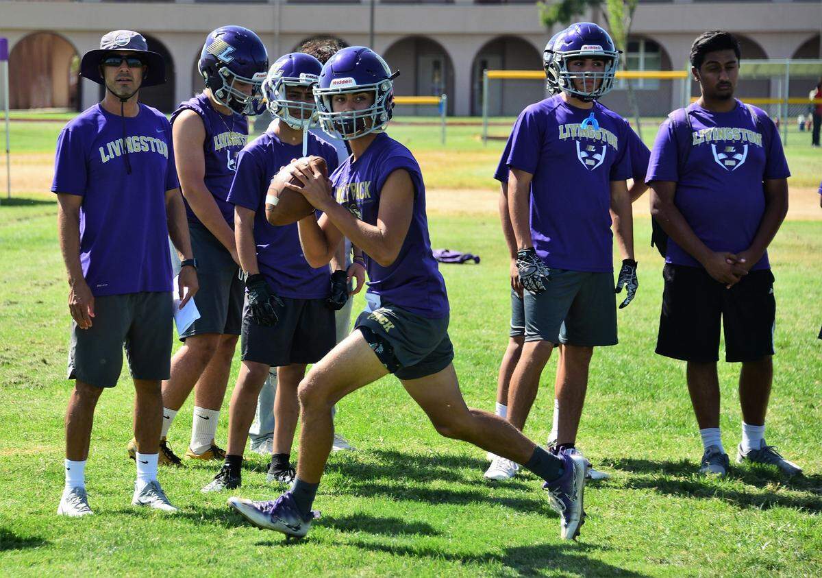 Livingston sophomore Rocklin Baptista looks to throw a pass as Wolves coach Alex Gonzalez (left) looks on during a practice on Wednesday, Sept. 11, 2019.