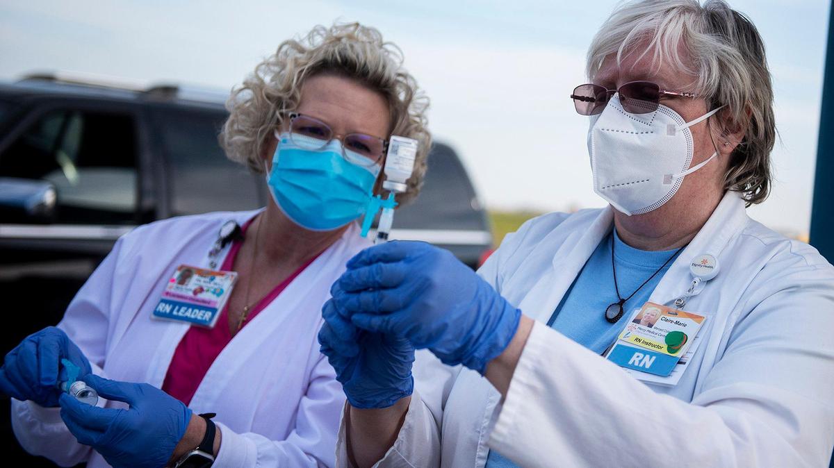 Registered Nurses Dawn Arnsberg, left and Claire Alvarez, right, fill syringes with COVID-19 vaccines at the Bear Creek Apartments in Planada, Calif., on Thursday, Feb. 25, 2021. According to Planada Elementary School District Superintendent Jose Gonzalez, the district partnered with Dr. Sima Asadi to administer about 300 vaccines to residents involved in the agriculture and food industry.