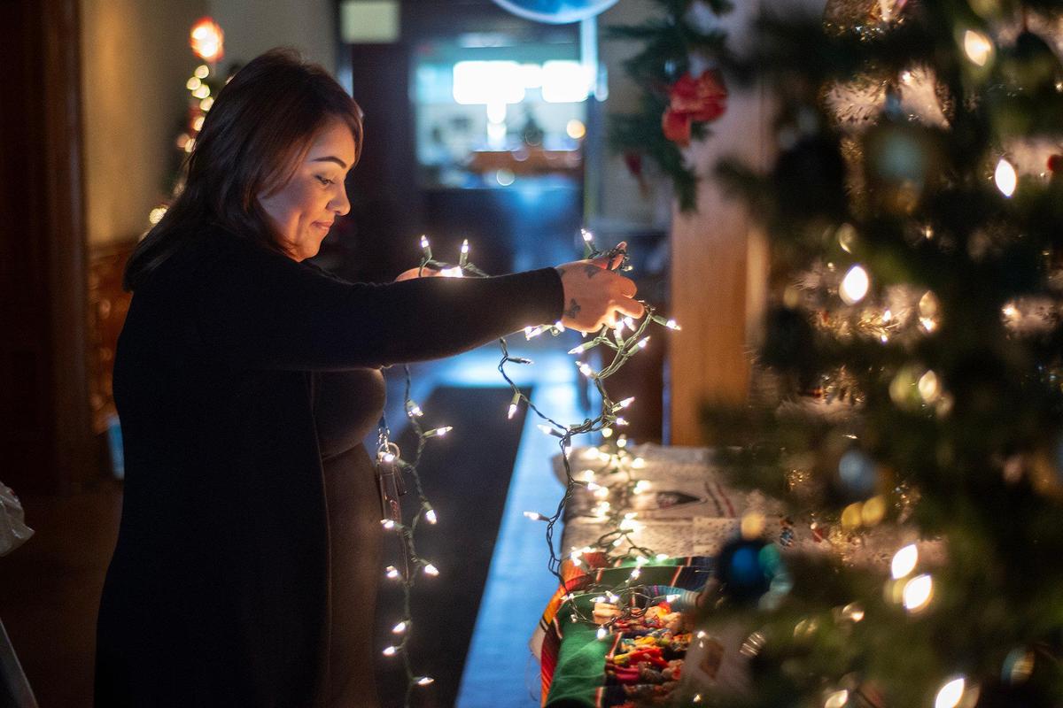 Susana Santana, 33, of Merced, decorates the Healthy House Merced Christmas tree at the Merced County Courthouse Museum on Wednesday, Nov. 27, 2024. The annual Christmas tree exhibit features more than 80 trees and runs through Dec. 30. A Christmas Tree open house will be held on Dec. 1 and include live entertainment including musical performances.