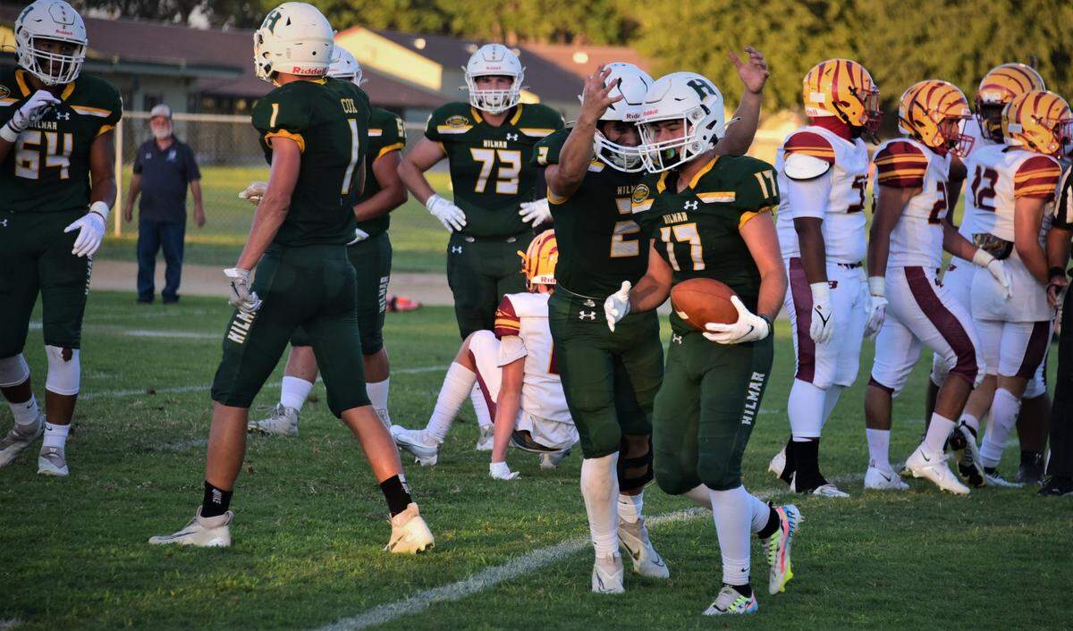 Hilmar High School running back Jax Branco (17) is congratulated by quarterback Hudson Azevedo after Branco scored on a 3-yard touchdown run in the first quarter during the Yellowjackets’ 21-7 win over Los Banos on Friday, Aug. 26, 2022.