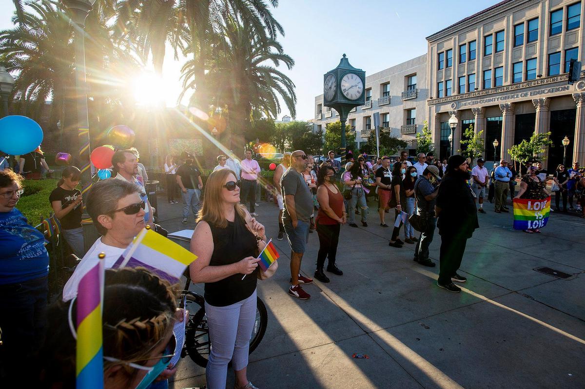 Members of the community look on during the Pride Progress flag raising ceremony at Bob Hart Square in Merced, Calif., on Wednesday, June 1, 2022. The Merced City Council approved the addition of the Pride flag to the regular flag calendar, meaning the flag will fly over Bob Hart Square annually during the month of June.