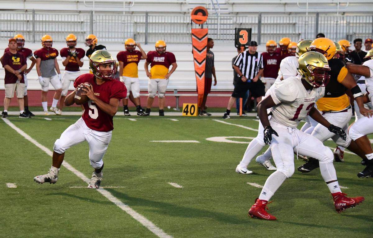 Golden Valley quarterback Jonathan Peredia rolls out to the right before delivering a pass against Los Banos during a scrimmage on Friday, Aug. 16, 2019 at Veterans Stadium.