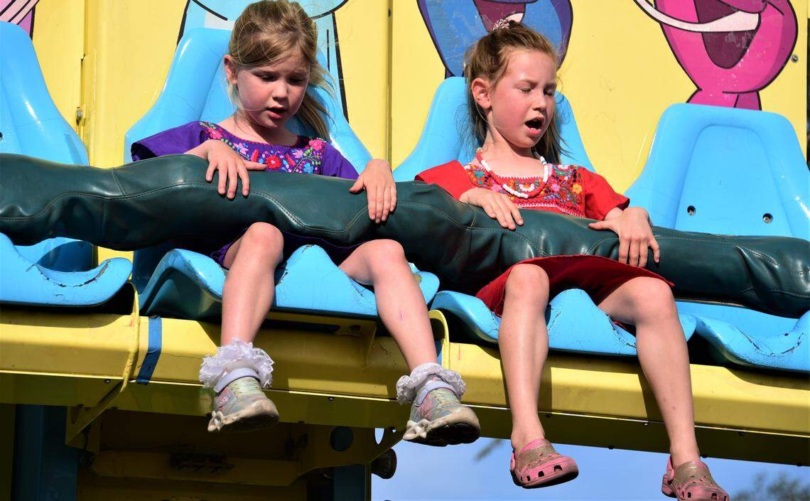 Sisters Phoebe Van Horn, 6, left, and Marisol Van Horn, 7, ride one fo the rides at the Merced County Fair on Wednesday, June 8, 2022.