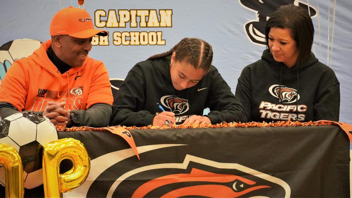 El Capitan High senior Anaya Shelton (center) signs her national letter of intent to accept a soccer scholarship to the University of the Pacific while her father Brian and mother Rosie look on during a ceremony on Thursday, Feb. 17, 2022 at El Capitan High School.