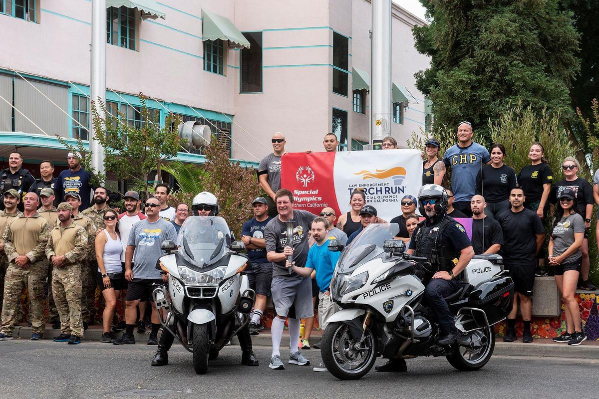 Merced County law enforcement officers and athletes pose for photos at Bob Hart Square following the Law Enforcement Torch Run for Special Olympics Northern California in Merced, Calif., on Wednesday, June 22, 2022. This year marks the 25th anniversary of the Law Enforcement Torch Run for the Special Olympics Northern California.