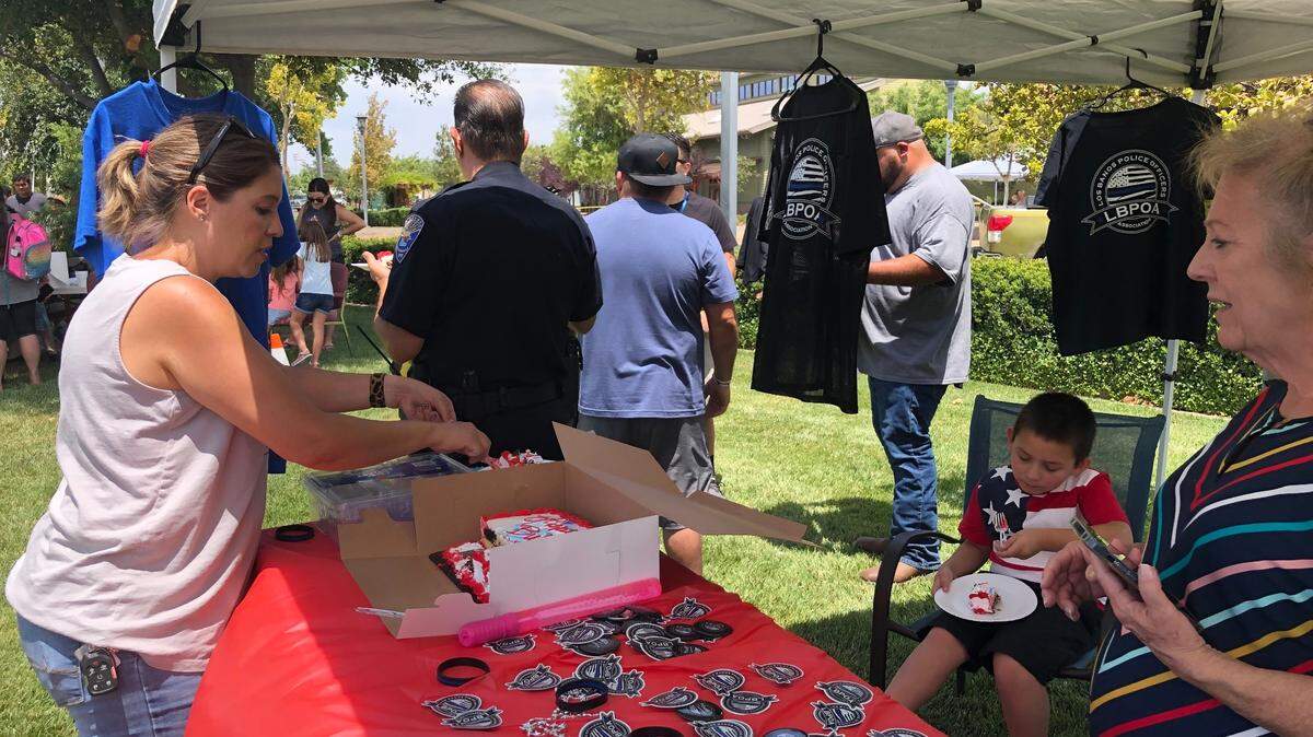 Los Banos Community and Economic Development Director Stacy Elms cuts a piece of cake for Sharon Silva, the executive director of the Los Banos Downtown Association, to mark a Fourth of July weekend celebration Saturday, July 3, 2021.