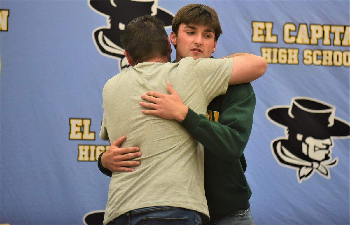 El Capitan High School senior Brody Collins hugs his father Doug after signing his national letter of intent to accept a basketball scholarship to Concordia University in Irvine on Friday, April 21, 2023 in the El Capitan gymnasium.