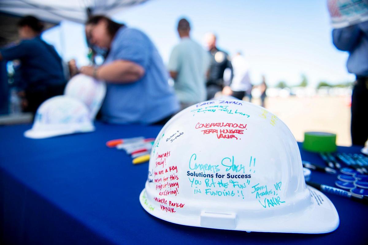 People write messages on hard hats during a groundbreaking ceremony for the new Los Banos police station in Los Banos, Calif., on Thursday, May 19, 2022. The site is located at 1111 G Street.