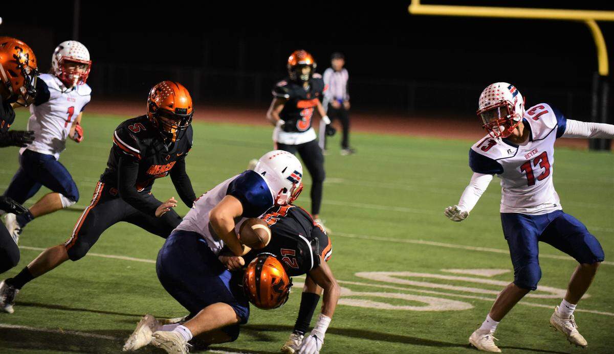 Merced High defensive back Jeremiah Robinson knocks the ball free from Beyer’s Zacchaeus Carillo. The Bears would recover the fumble and go on to defeat the Patriots 20-6 on Friday, Nov. 8, 2019 at Veterans Stadium in Merced, Calif.
