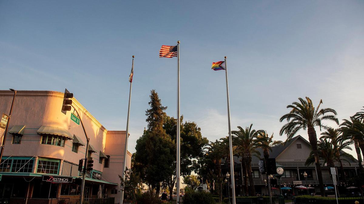 The Progress Pride flag waves over Bob Hart Square following a ceremony to celebrate the raising of the flag in Merced, Calif., on Tuesday, June 1, 2021. According to Adam Lane, president of the Merced LGBTQ+ Alliance, the flag contains the traditional rainbow colors as well as the transgender pride colors with a black and brown stripe to represent people of color.