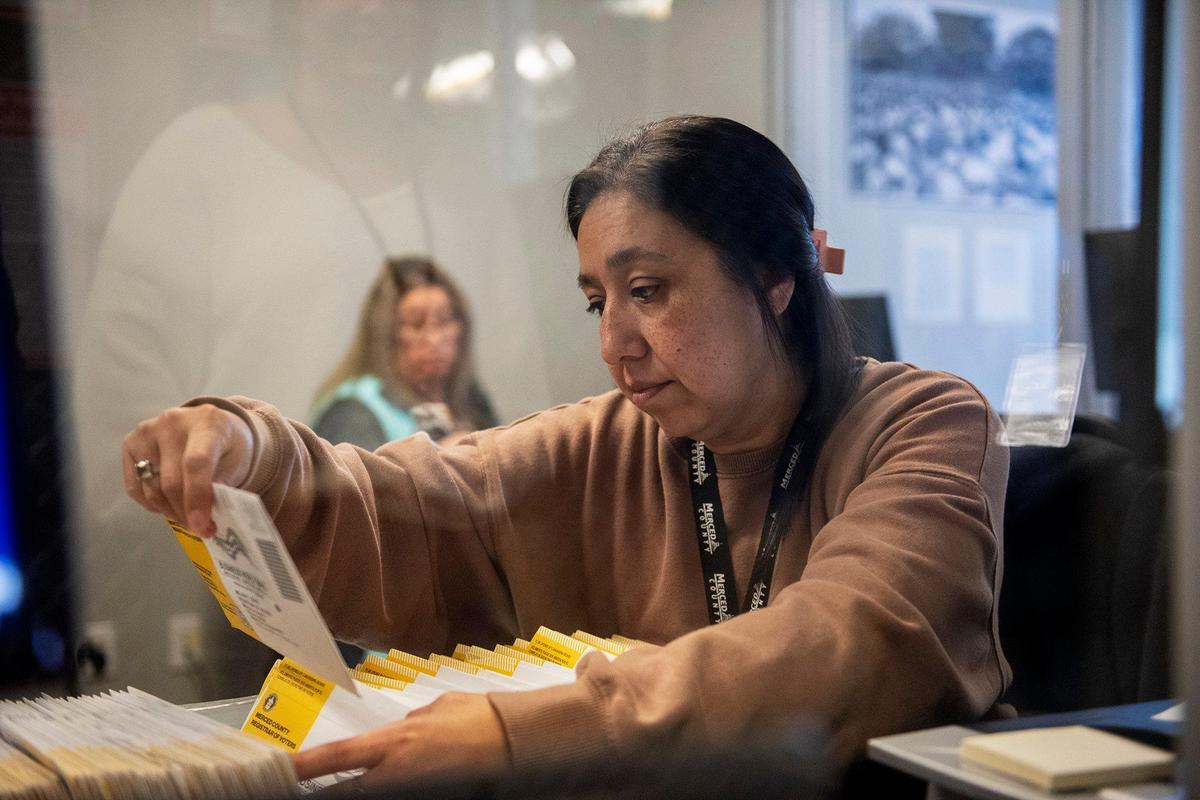 Extra help election worker Christina Ruiz, 44, of Catheys Valley, works to verify signatures on vote-by-mail ballots to signatures on file, at the Merced County Election Warehouse in Merced, Calif., on Thursday, Nov. 7, 2024. Election officials and workers continue to count tens of thousands of ballots following the Nov. 5, General Election.
