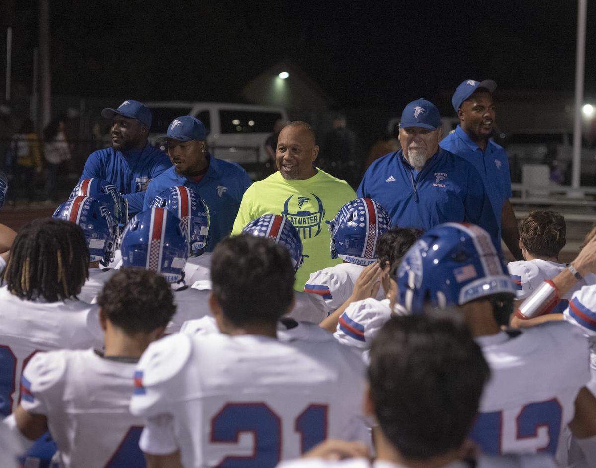 Atwater head coach Seneca Ybarra, center, celebrates with his players following the Falcons’ comeback win over Los Banos.