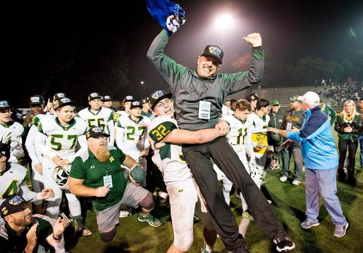 Hilmar runningback Justin Rentfro lifts his coach Frank Marques after the Yellowjackets beat the Modesto Christian Crusaders 42-13 in the Sac-Joaquin Section Division VI final at Lincoln High School in Stockton, Calif., on Saturday, Nov. 25, 2017.