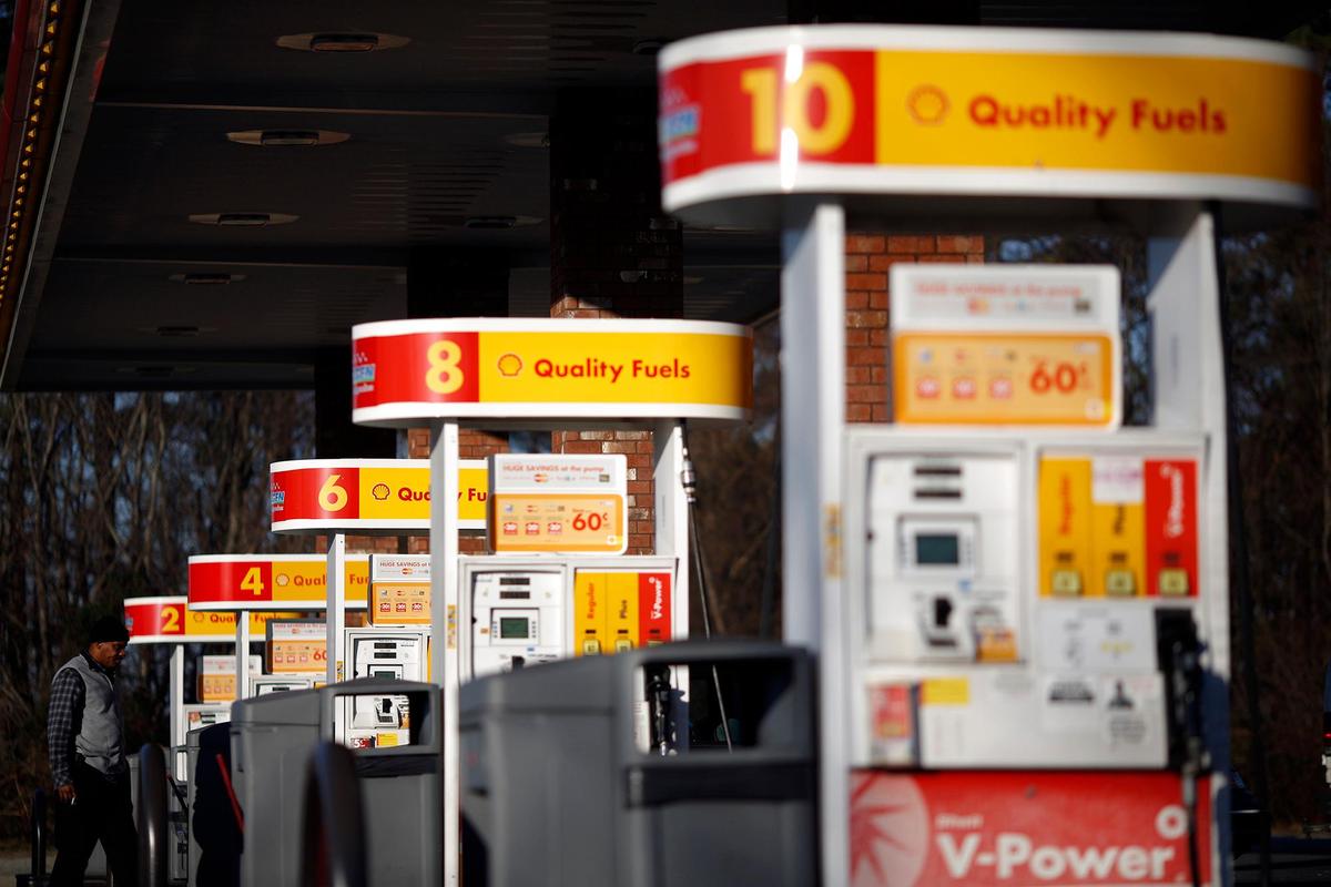 A motorist waits for his gas tank to fill at a Shell station.
