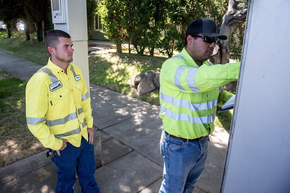 Tanner Harkreader, a lead lighting technician with the City of Merced, performs routine maintenance on a traffic signal cabinet at the intersection of Olive and Parsons avenues in Merced, Calif., on Thursday, July 31, 2025. 