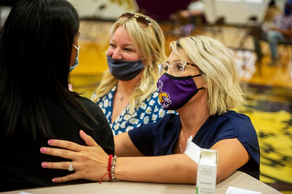 Corinne Hurtado, right, a registered nurse for Livingston High School, and Cristi Johnson, center, director of student services for the Merced Union High School District, comfort a student before receiving the Pfizer COVID-19 vaccine during a vaccination clinic held by the MUHSD in partnership with Castle Family Health Centers, for children 12 years of age and older at Livingston High School in Livingston, Calif., on Thursday, May 13, 2021. According to the school district, the clinic was also open to parents and family members who have not yet received the vaccine.