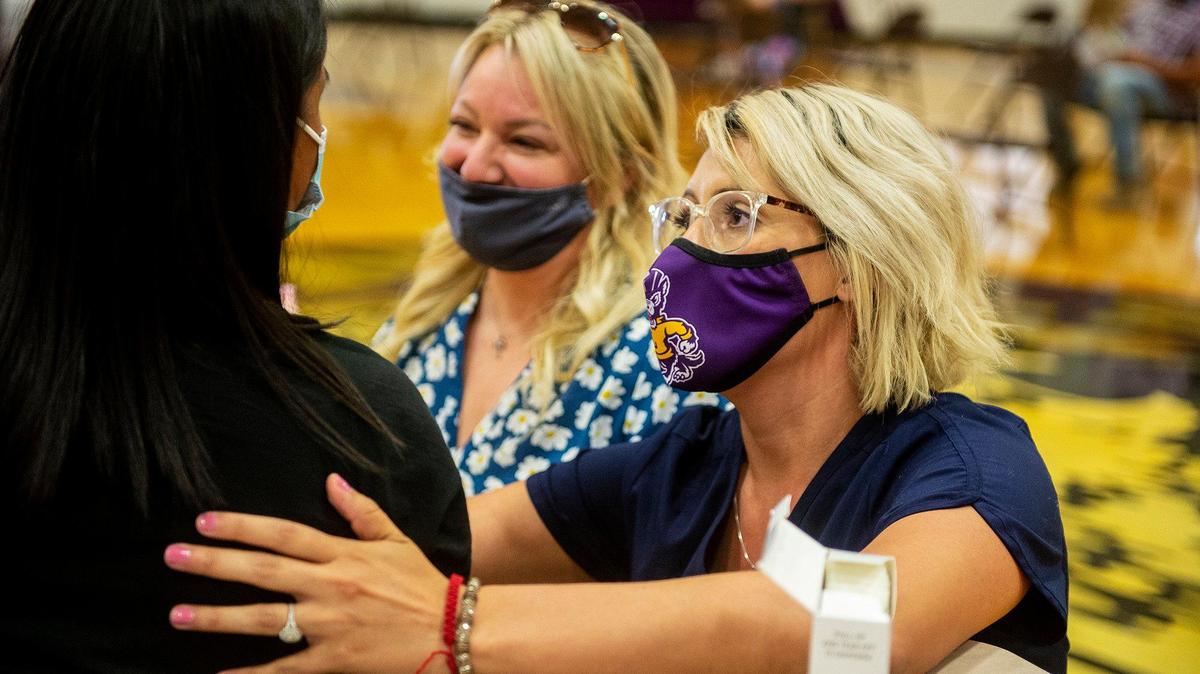 Corinne Hurtado, right, a registered nurse for Livingston High School, and Cristi Johnson, center, director of student services for the Merced Union High School District, comfort a student before receiving the Pfizer COVID-19 vaccine during a vaccination clinic held by the MUHSD in partnership with Castle Family Health Centers, for children 12 years of age and older at Livingston High School in Livingston, Calif., on Thursday, May 13, 2021. According to the school district, the clinic was also open to parents and family members who have not yet received the vaccine.