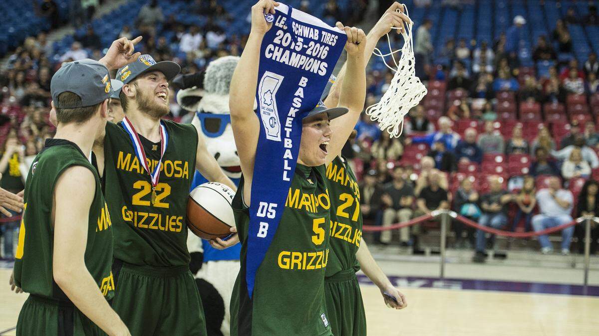 Mariposa senior Bradley Chambers (5) carries the division championship pennant after defeating the Brookside Christian Knights 79-75 in the Sac-Joaquin Section Division V Championship game at Sleep Train Arena in Sacramento, Calif., Friday, March 4, 2016.
