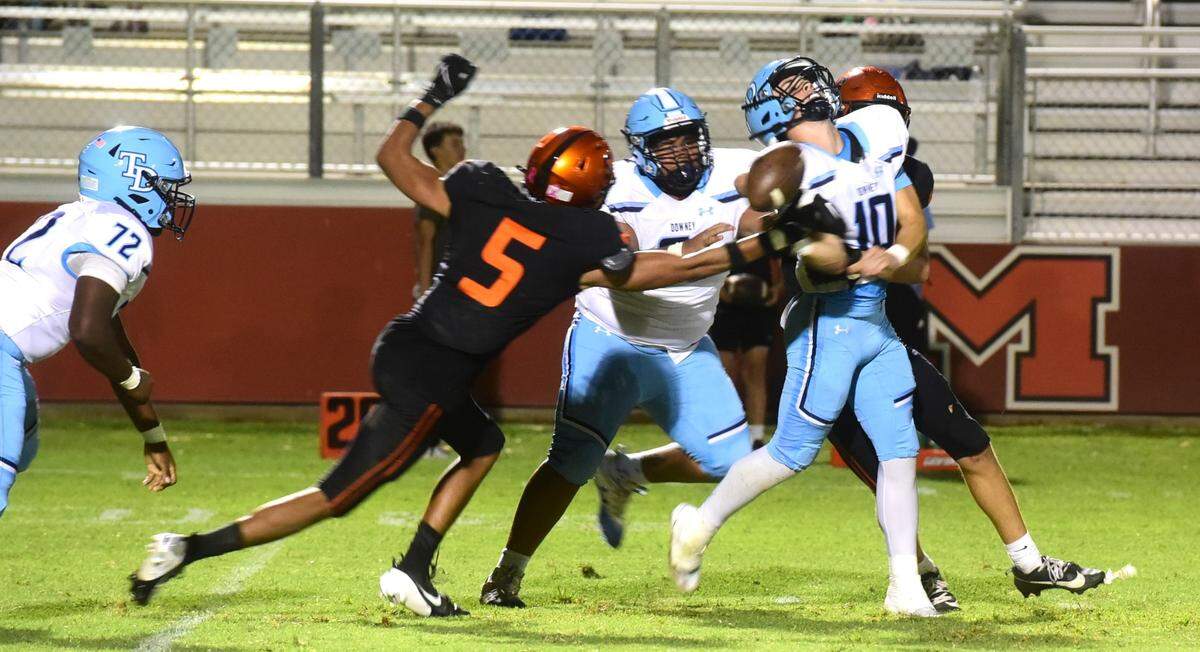 Merced High senior defensive end Jatavious Lewis (5) strips the ball from Downey quarterback Carson Lamb during a game on Friday, Sept. 6, 2024.