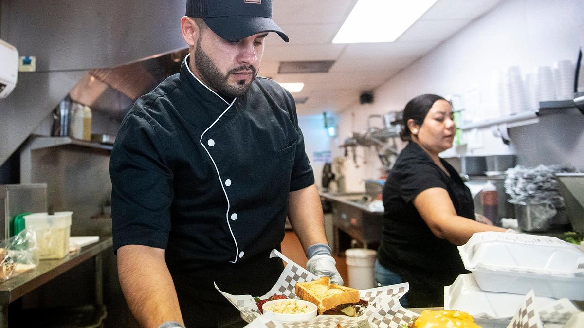 El jefe de cocina Antonio Cervantes, de 32 años, de Livingston, a la izquierda, y la cocinera de línea María González, de 41 años, de Winton, a la derecha, preparan pedidos para los clientes en el restaurante Tri-Tipery, ubicado en 11359 Newport Road, en Ballico, California, el jueves 13 de junio de 2024.