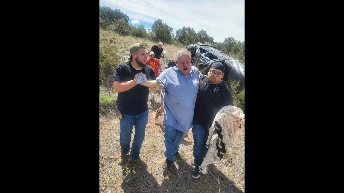 Los agentes de reserva del Departamento de Policía de Gustine Luciano Zelvaggio, a la izquierda, y José Gallardo, a la derecha, ayudan a un automovilista después de sacarlo de un accidente vehicular en Interstate 40, cerca de Kingman, Arizona, el lunes 11 de septiembre de 2023. Según el Departamento de Policía de Gustine, los tres agentes de reserva se detuvieron para rescatar al hombre mientras conducían vehículos del departamento de policía recién adquiridos para California. Imagen cortesía del Departamento de Policía de Gustine.