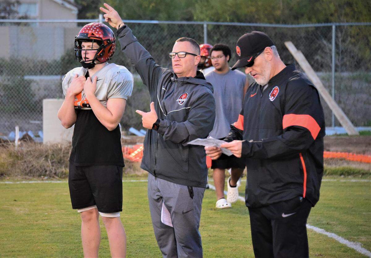 Merced High football coach Rob Scheidt (center) signals in a play while his son and Bears quarterback Seth Scheidt (left) looks on at practice on Tuesday, Nov. 23, 2021. The Bears will play Vanden for the Sac-Joaquin Section Division IV championship on Saturday at St. Mary’s High School in Stockton, Calif.
