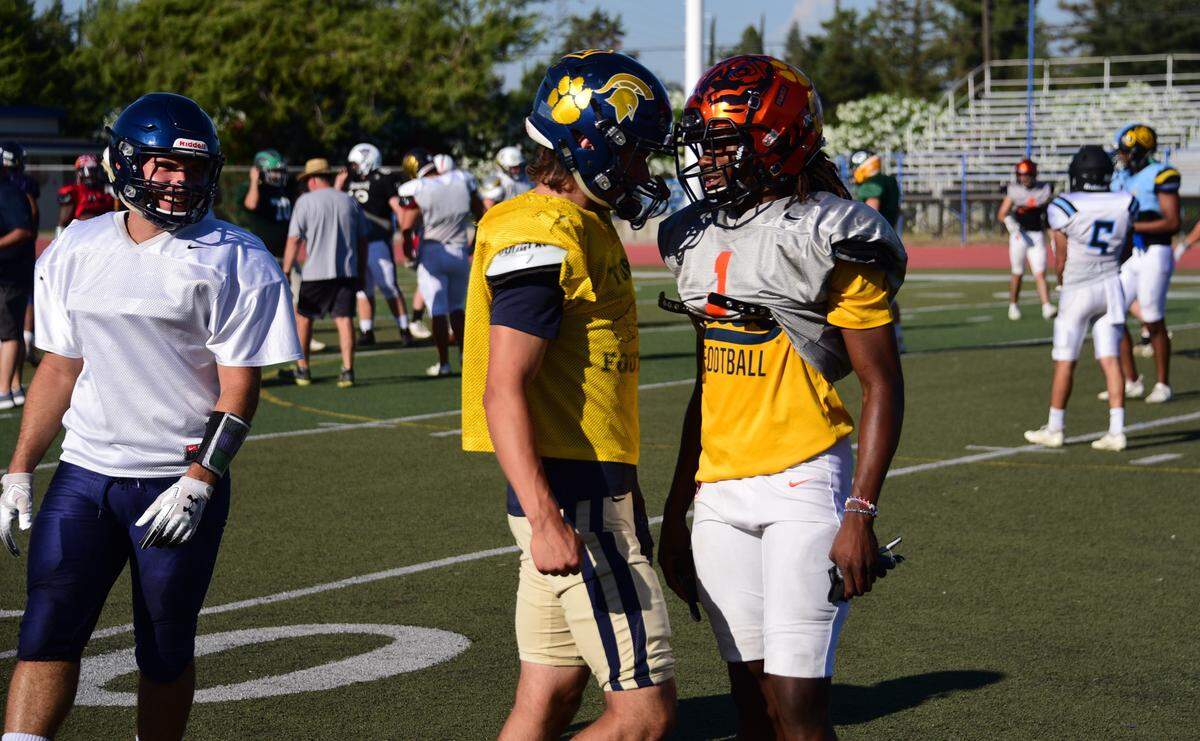 Former Merced defensive back Dhameer Warren (1) chats with former Turlock quarterback Jonah Kosakiewicz during a South team practice at Atwater High on Tuesday, June 18, 2019. 