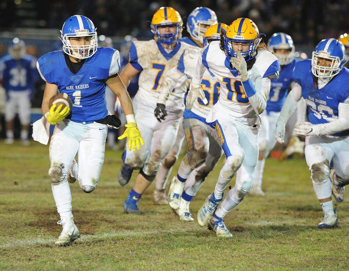 Caruthers High School running back, Andrew Gonzalez, left, runs past a host of Dos Palos defenders in the third quarter Friday, Nov. 29, 2019 in Caruthers.