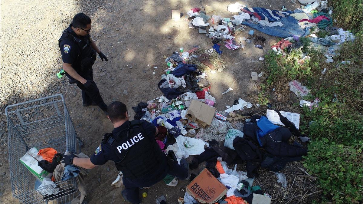 Disruptive Area Response Team officers as well as City of Merced Public Works employees work to cleanup homeless encampments along 16th Street in Merced on Thursday, May 7, 2020. According to the Merced Police Department, the cleanups were conducted due to possible fire hazards as well as to address public health and safety concerns.