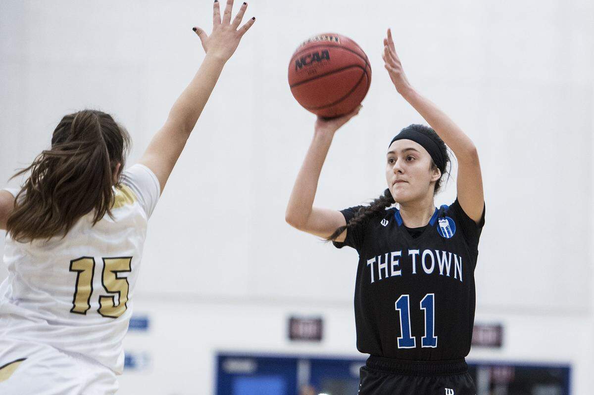 Atwater senior Lexi Valencia (11) attempts a shot over Buhach Colony senior Adrianna Mariscal (15) during a game at Atwater High School in Atwater, Calif., on Thursday, Jan. 17, 2019.