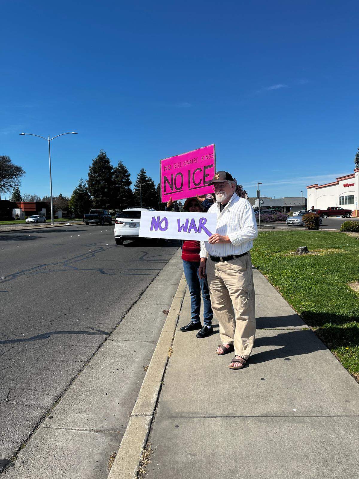 Demonstrators holding signs in protest of ICE and war.