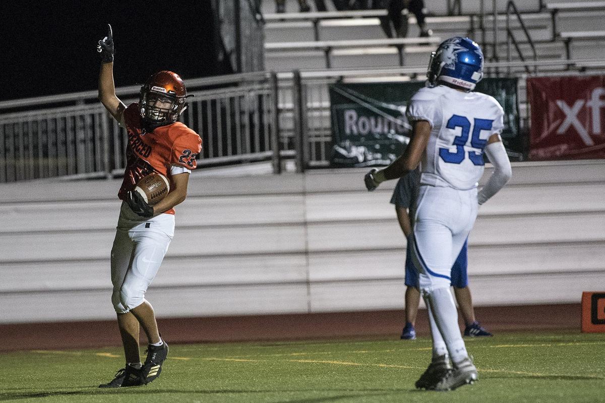 Merced junior Misael Aguirre (23) points to the sky after scoring a touchdown during a game against Madera at Veterans Stadium on the campus of Golden Valley High School in Merced, Calif., on Friday, Sept. 7, 2018. The Bears beat the Coyotes 63-35.