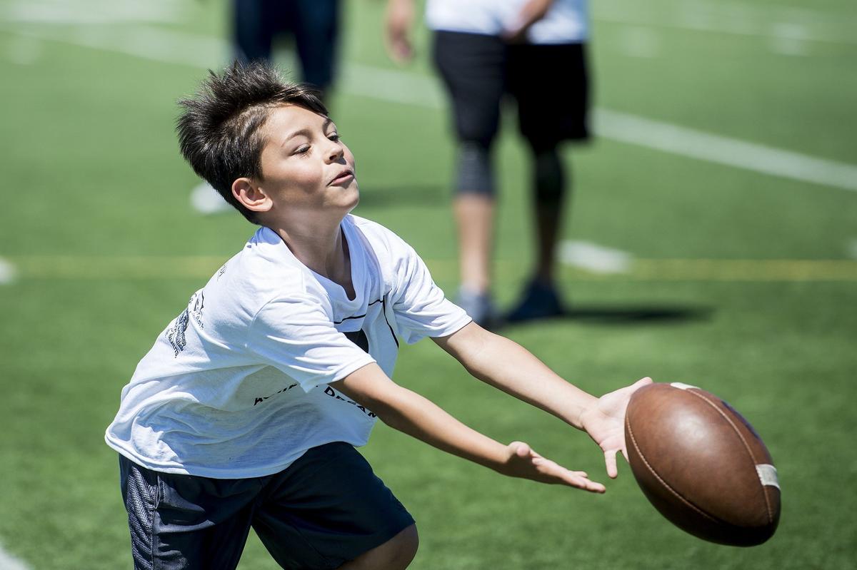 Timothy Mallory, 8, of Merced, attempts to catch a pass during the Achieve Dreams Youth Football Camp at Veterans Stadium on the campus of Golden Valley High School in Merced, Calif., on Saturday, May 12, 2018. The camp is hosted by Golden Valley graduate and Canadian Football League all-star Chris Randle. This is the second year Randle has hosted the camp which is offered free of charge to children ages 6-18.