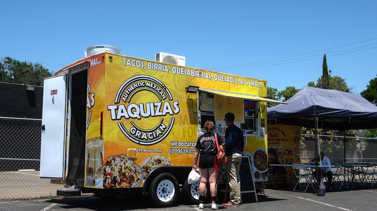 Customers pick up an order from Taquizas Gracian food truck, located at 825 West Main Street in Merced, Calif., on Tuesday, June 10, 2025.