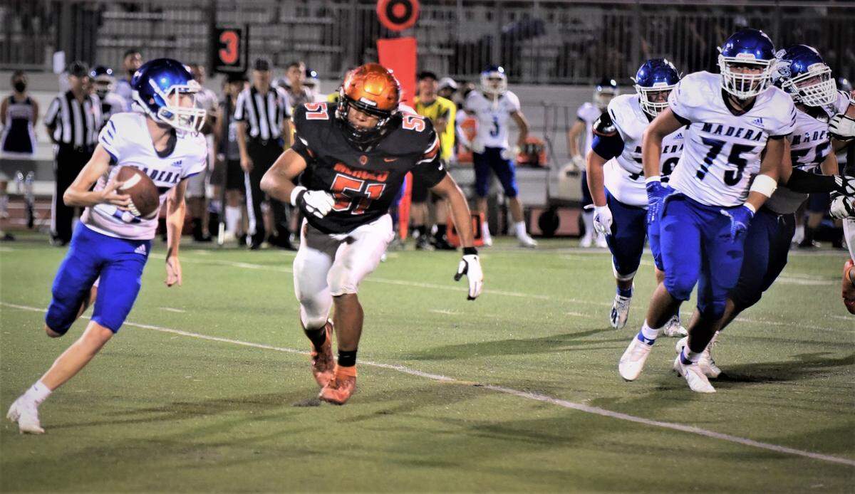 Merced senior Jaylen Thao-Booth chases down Madera quarterback Ty Davis during a game on Thursday, Sept. 9, 2021 at Veterans Stadium in Merced, Calif.