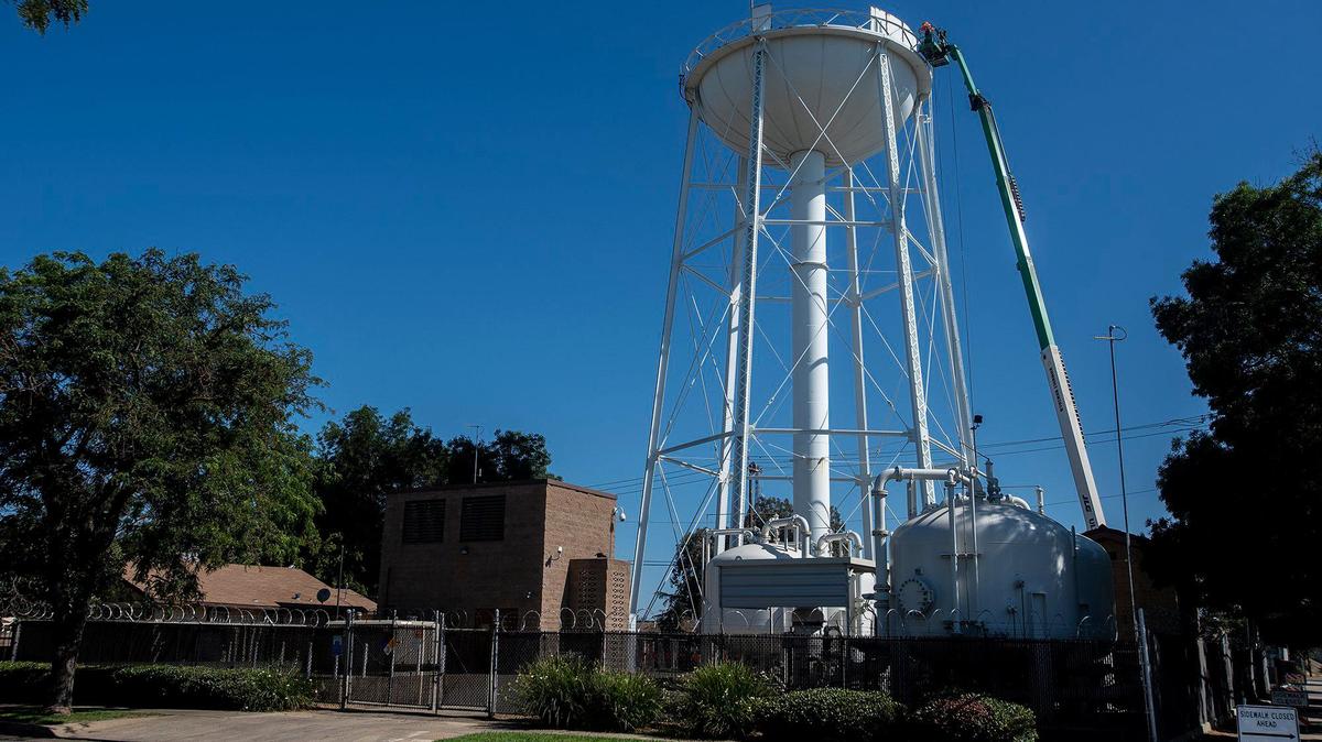 Workers dismantle a water tower near the intersection of 12th Street and Canal Street in Merced, Calif., on Thursday, July 22, 2021.