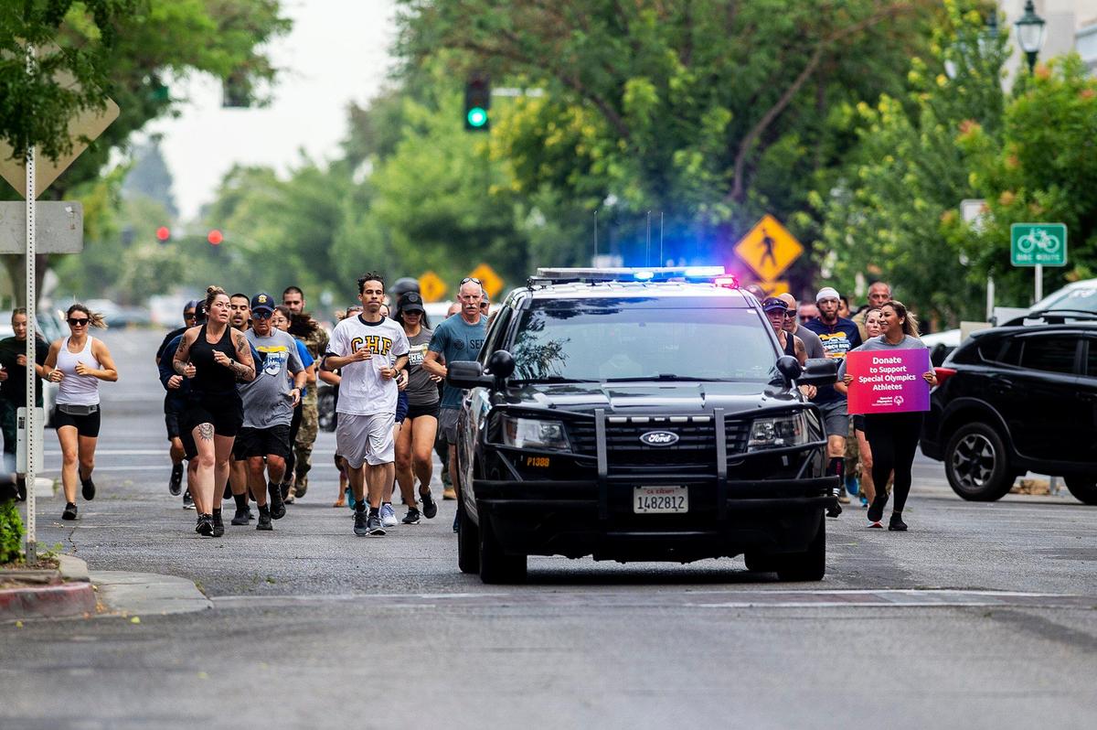 Merced County law enforcement officers and participants make their way along West Main Street toward Bob Hart Square during the Law Enforcement Torch Run for Special Olympics Northern California in Merced, Calif., on Wednesday, June 22, 2022. This year marks the 25th anniversary of the Law Enforcement Torch Run for the Special Olympics Northern California.