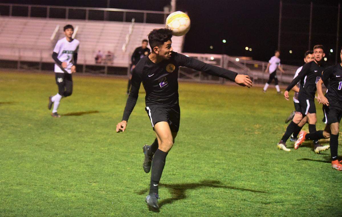 Livingston High defender David Lozano heads the ball during a playoff match against Dixon on Tuesday, Feb. 15, 2021 in Livingston, Calif.