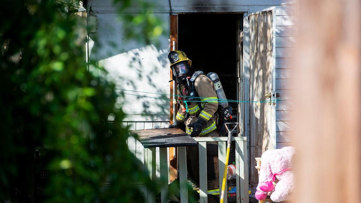 A firefighter removes items from the back room of a West 18th Street home after a structure fire in Merced, Calif., on Wednesday, April 14, 2021. According to Battalion Chief Mickey Brunelli, the fire was located in the back room of the two-story structure. The house was occupied by two people at the time of the fire and no injuries were reported. The cause of the fire is under investigation, according to fire officials.