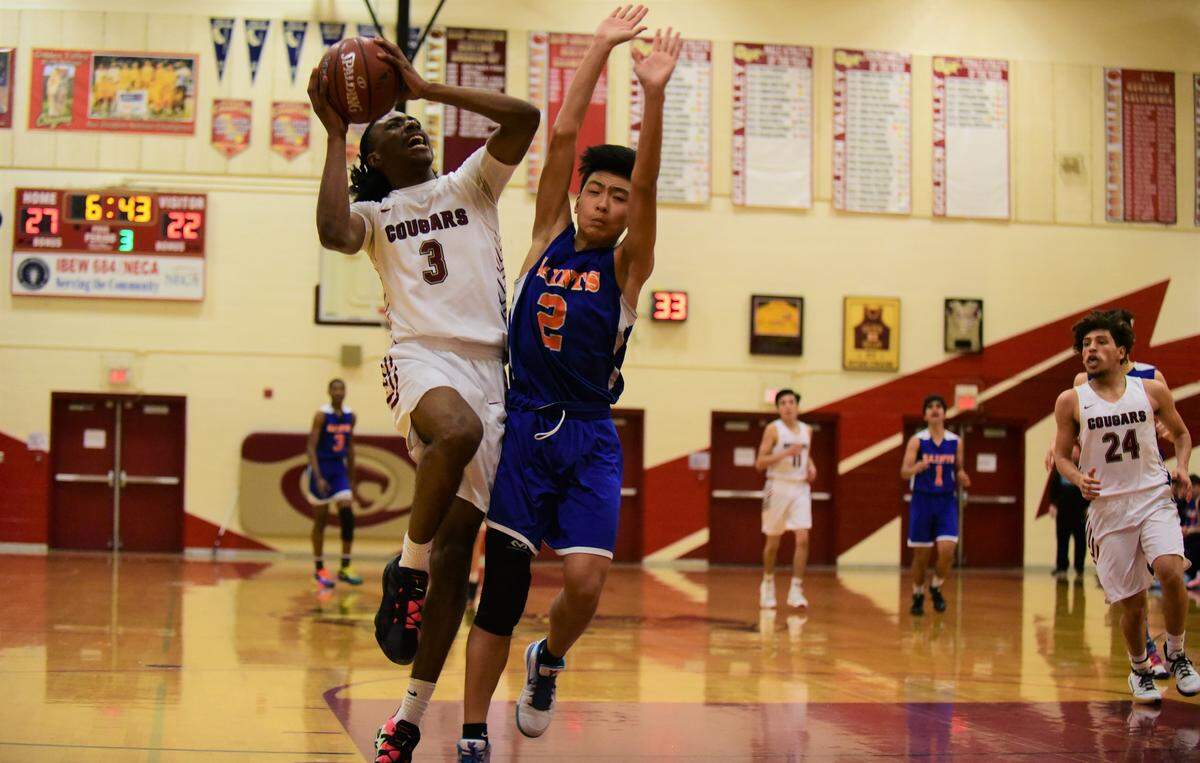 Golden Valley senior Aurrion Harris draws a foul from Santa Teresa’s Son Pham during Tuesday night’s Northern California playoff game. Harris scored 25 points and pulled down 15 rebounds in a 61-41 win for the Cougars.