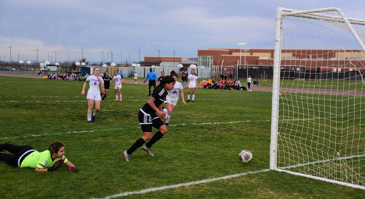 El Capitan sophomore Anaya Shelton pounces on a goal after Kimball goalie Jordan Claire mishandles a free kick to tie the game at 1-1 in the first half of a playoff match on Friday, Feb. 21, 2020 at El Capitan High School.