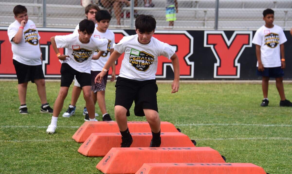 Rafael Muro, 12, practices his footwork at the David Perales Football Camp held at Merced High School on Saturday, July 13, 2024 in Merced, Calif.
