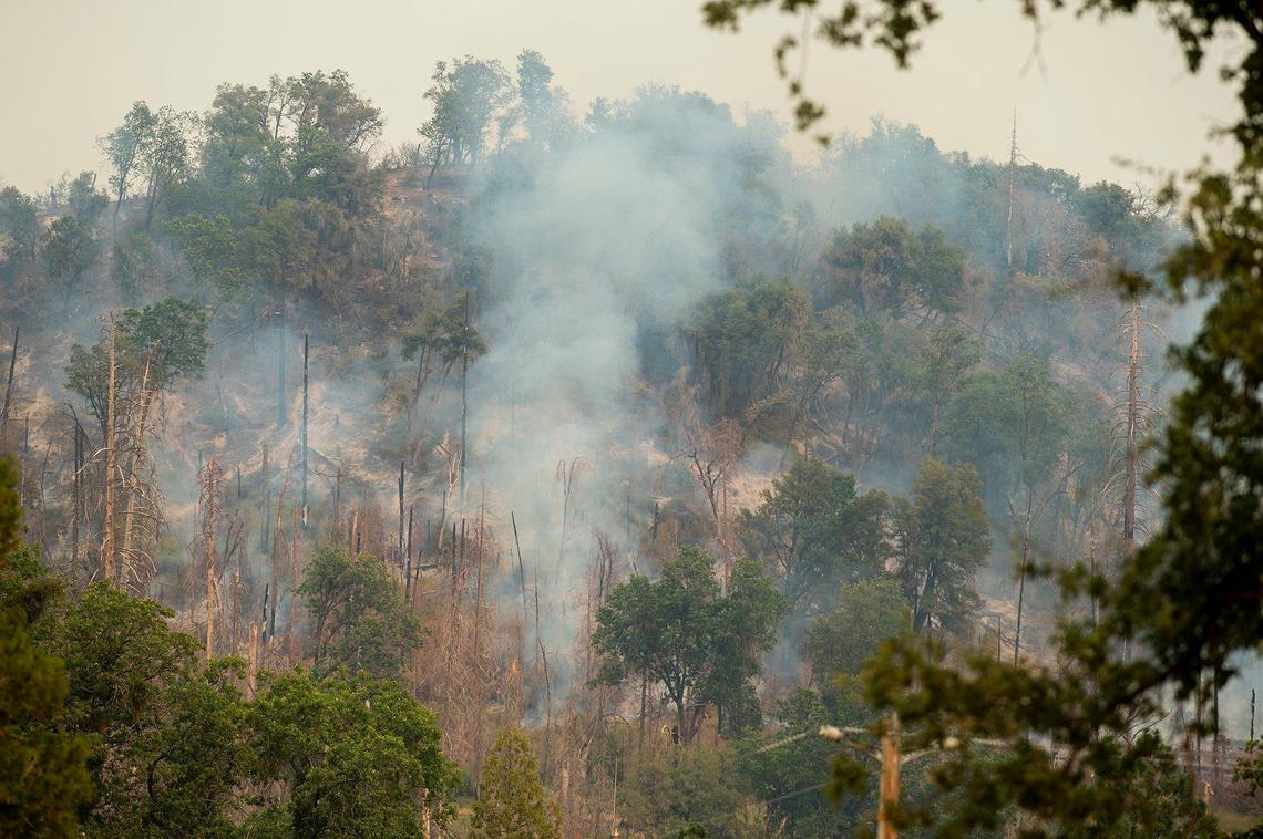 Smoke is seen from a hillside east of Scott Road as firefighters continue to battle the Oak Fire in Mariposa County, Calif., on Tuesday, July 26, 2022.
