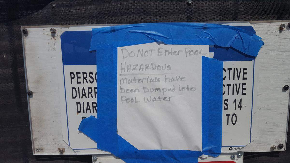 Signs warn people not to enter the Pacheco High pool. The pool is closed for the summer for repairs after someone dumped motor oil into the pool.